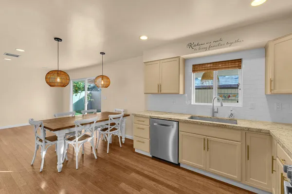 a kitchen with a table chairs sink and cabinets