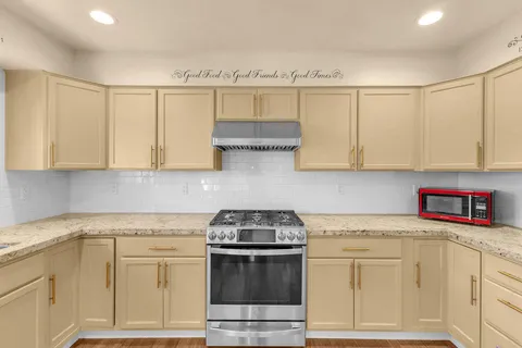a kitchen with stainless steel appliances granite countertop a sink stove and cabinets
