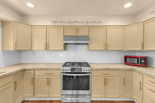 a kitchen with stainless steel appliances granite countertop a sink stove and cabinets