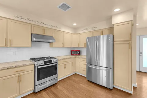a kitchen with stainless steel appliances a refrigerator sink and cabinets