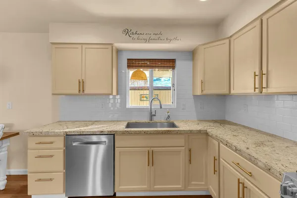 a kitchen with granite countertop white cabinets and a sink