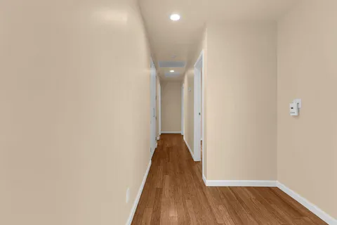 a view of a hallway with wooden floor