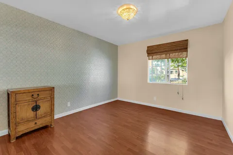 an empty room with wooden floor and window