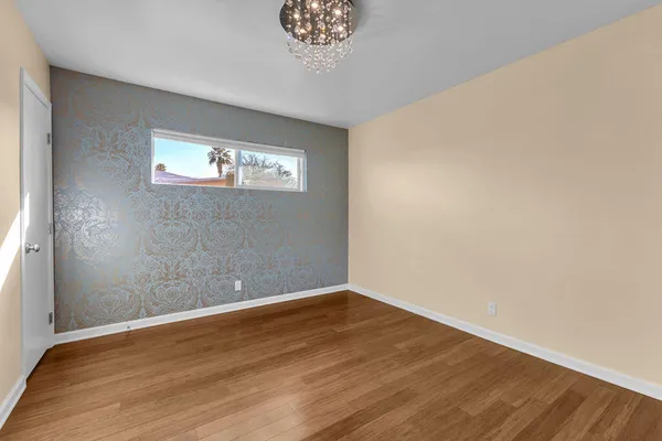 a view of a room with wooden floor and a window