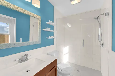 a bathroom with a sink a toilet and shower