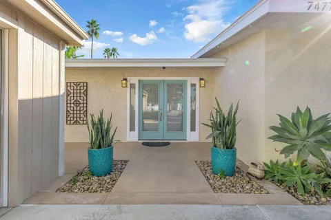a front view of a house with potted plants