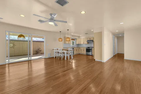 a view of a kitchen with dining table chairs and wooden floor
