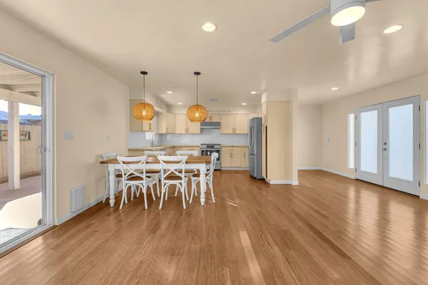 an open kitchen with wooden floor and large windows
