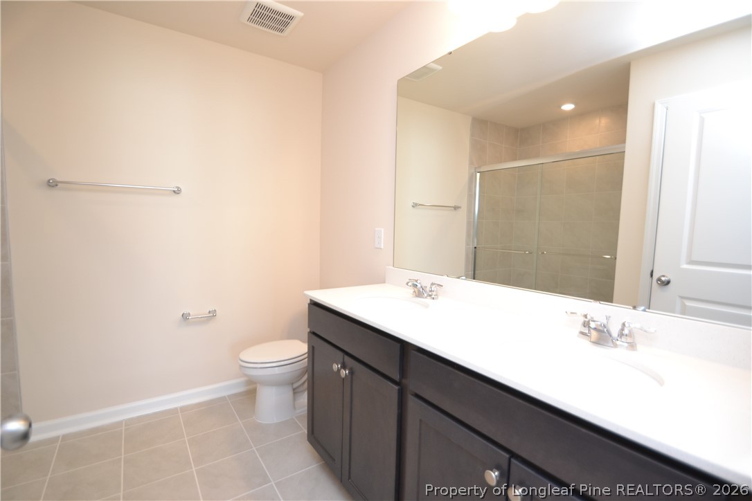 5703 Preveza Place Raleigh, NC 27603 - Photo 28 of 33 a bathroom with a sink a toilet and shower