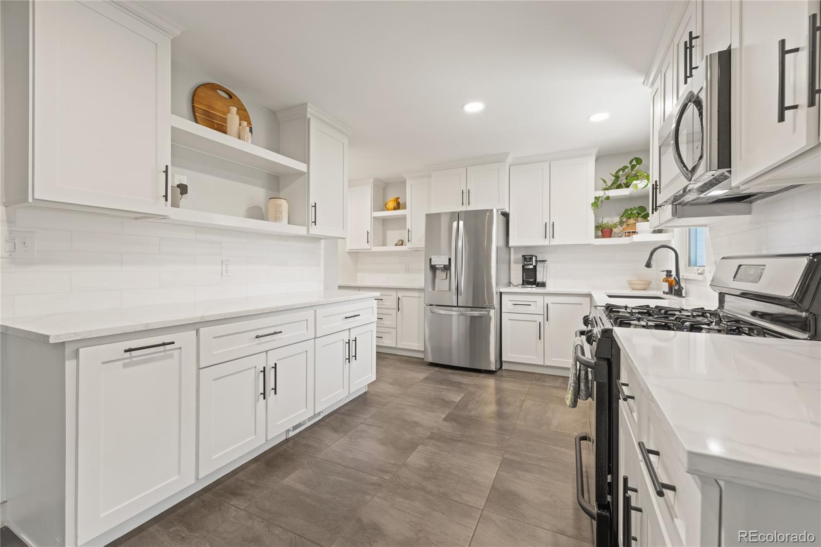 13402 West 24th Place Golden, CO 80401 - Photo 11 of 38 a kitchen with refrigerator a stove a sink and a refrigerator