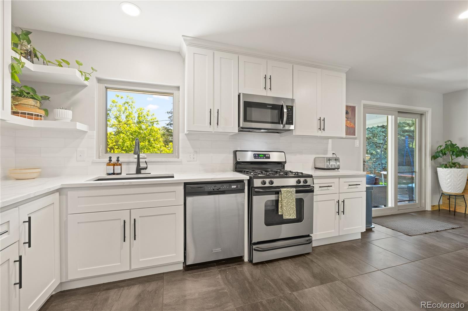 13402 West 24th Place Golden, CO 80401 - Photo 12 of 38 a kitchen with white cabinets and appliances