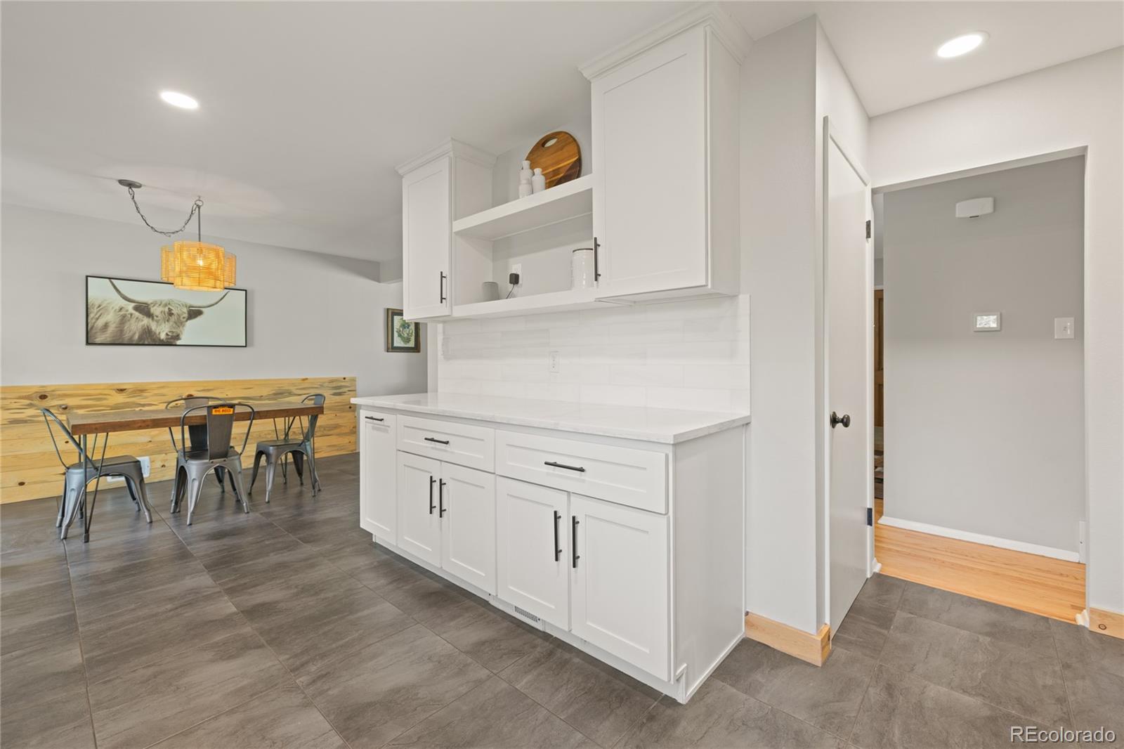 13402 West 24th Place Golden, CO 80401 - Photo 13 of 38 a kitchen with white cabinets and chairs