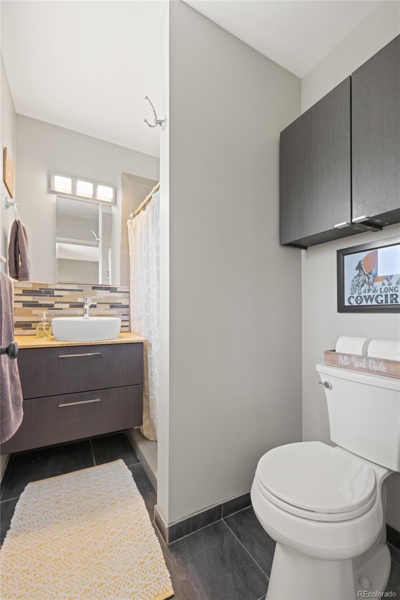 13402 West 24th Place Golden, CO 80401 - Photo 16 of 38 a bathroom with a toilet a sink and mirror