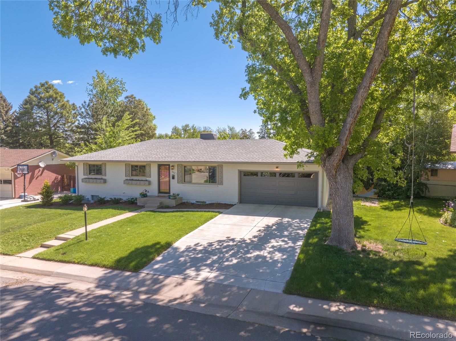 13402 West 24th Place Golden, CO 80401 - Photo 2 of 38 a front view of a house with a yard and garage