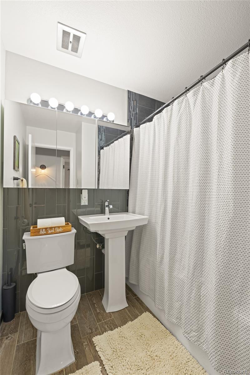 13402 West 24th Place Golden, CO 80401 - Photo 21 of 38 a bathroom with a sink toilet and shower
