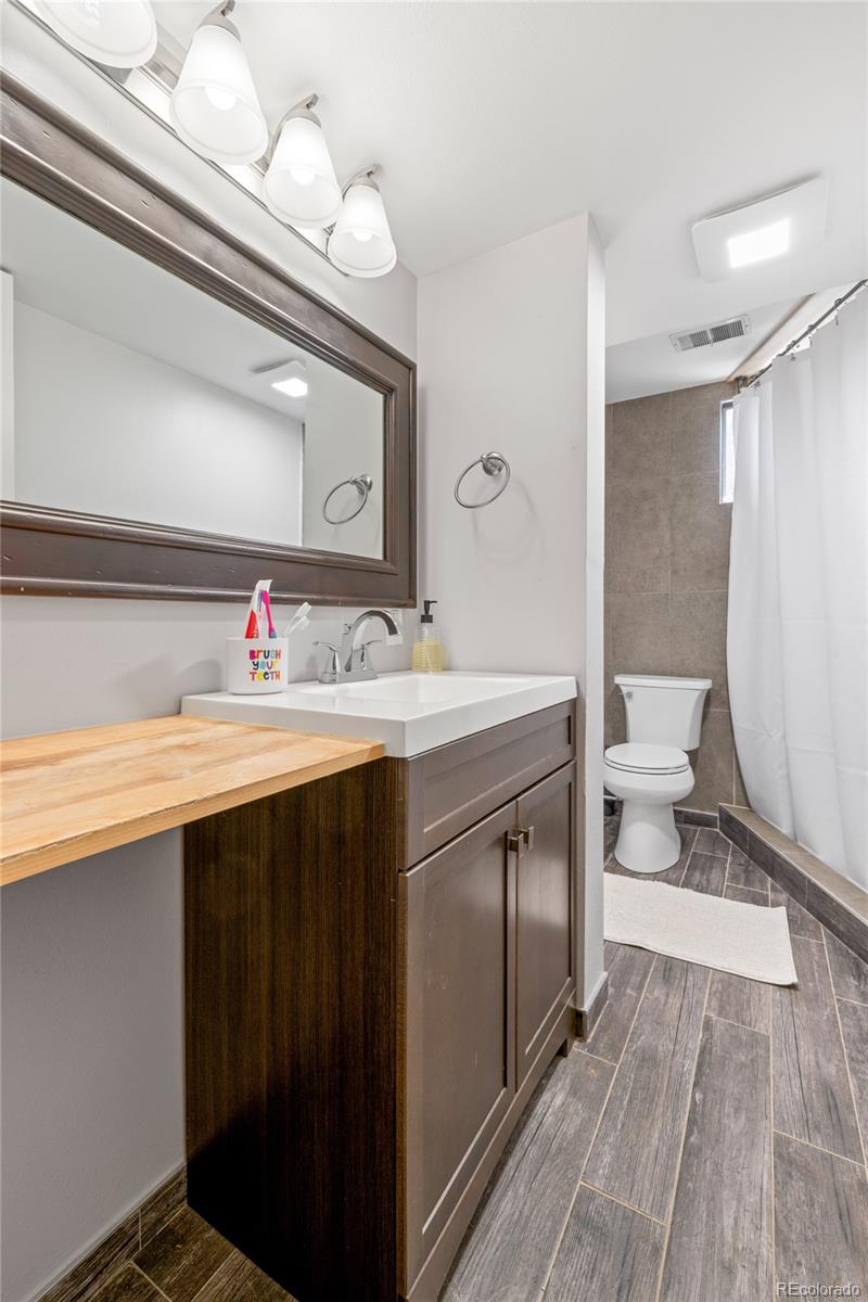 13402 West 24th Place Golden, CO 80401 - Photo 29 of 38 a bathroom with a sink vanity mirror and toilet