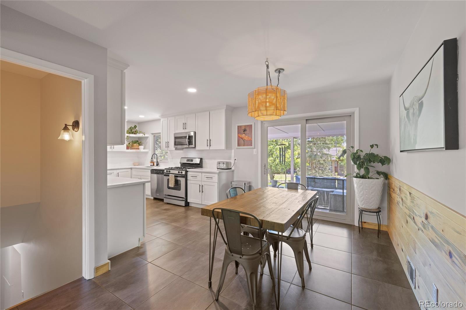 13402 West 24th Place Golden, CO 80401 - Photo 7 of 38 a kitchen with a table chairs refrigerator and cabinets