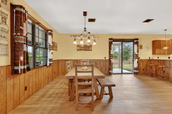 a view of a livingroom with furniture wooden floor windows and a chandelier