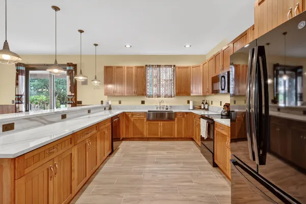 a large kitchen with stainless steel appliances granite countertop a stove a sink dishwasher and a refrigerator