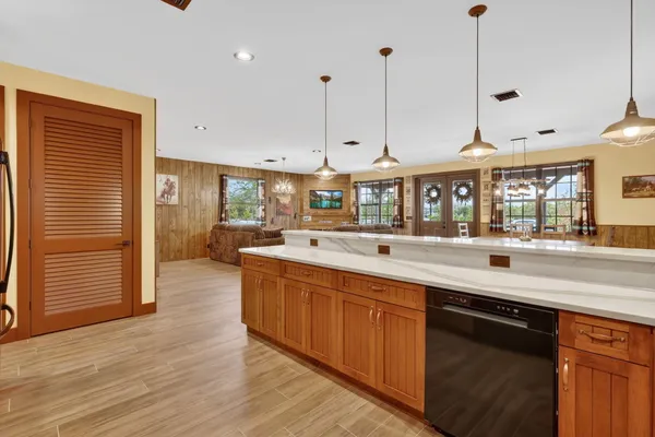 a open kitchen with stainless steel appliances granite countertop a sink a island a stove and a wooden floors