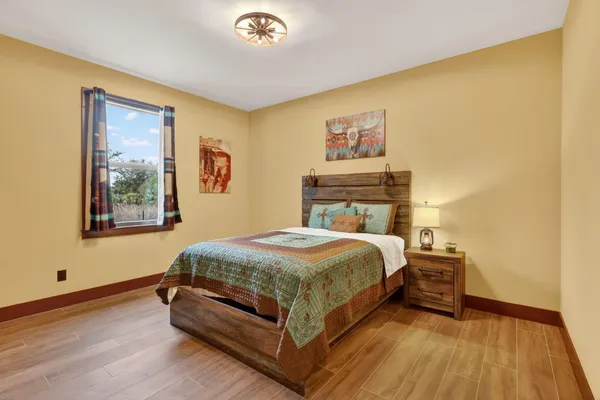 a bedroom with a bed and wooden floor