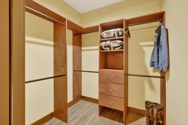 a view of walk in closet with wooden floor