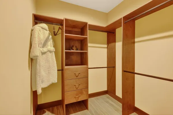 a view of walk in closet with clothes and shoes