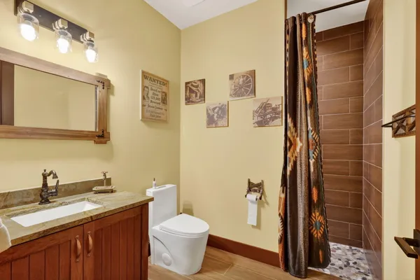 a bathroom with a double vanity sink toilet and shower