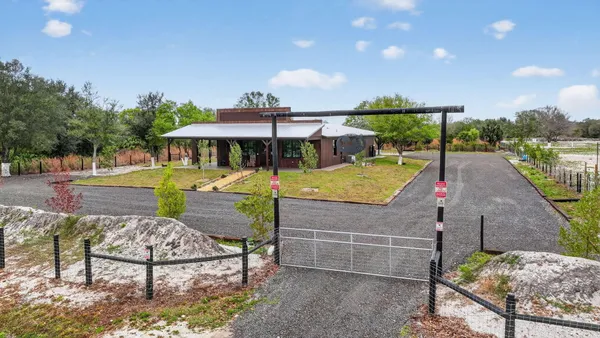 a view of a swimming pool with a patio and a yard