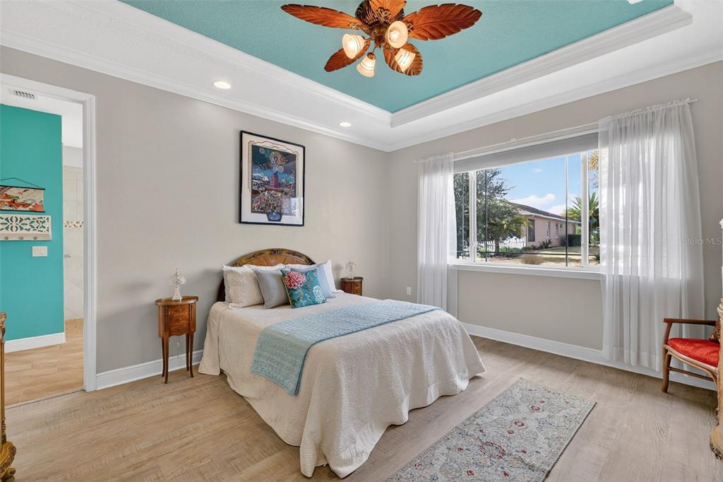 9630 Southwest 86th Place Ocala, FL 34481 - Photo 24 of 42 a bedroom with a bed and a chandelier