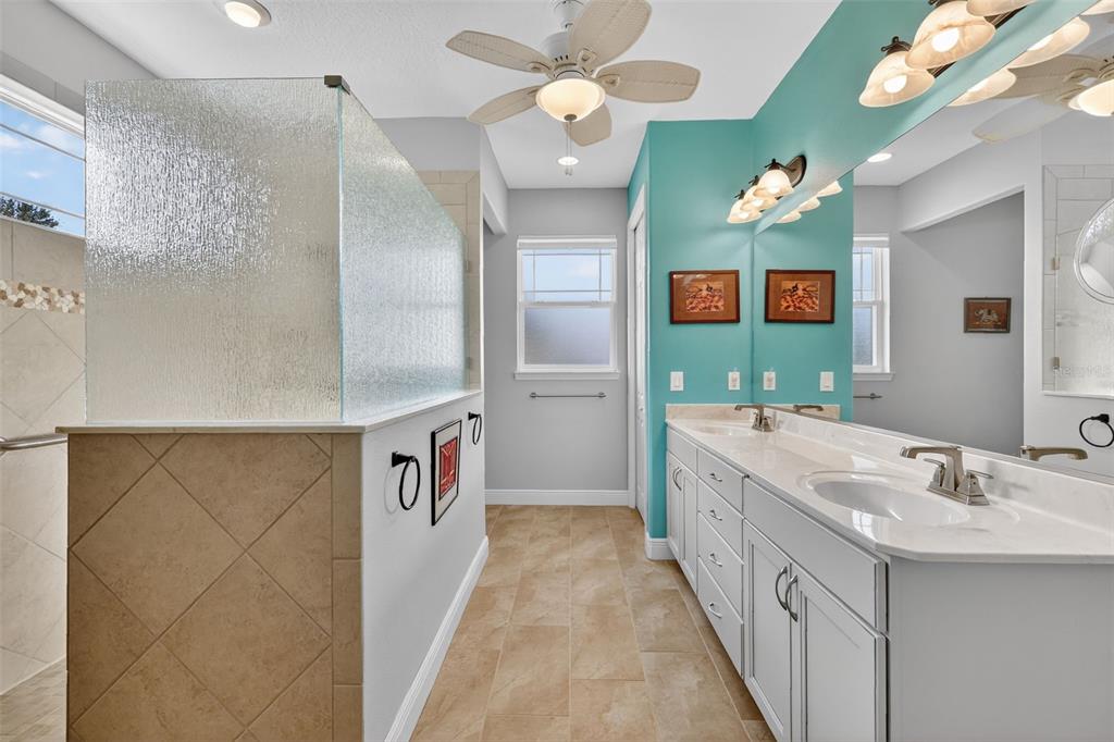9630 Southwest 86th Place Ocala, FL 34481 - Photo 26 of 42 a bathroom with a sink a vanity a mirror and a shower