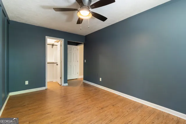 an empty room and chandelier fan