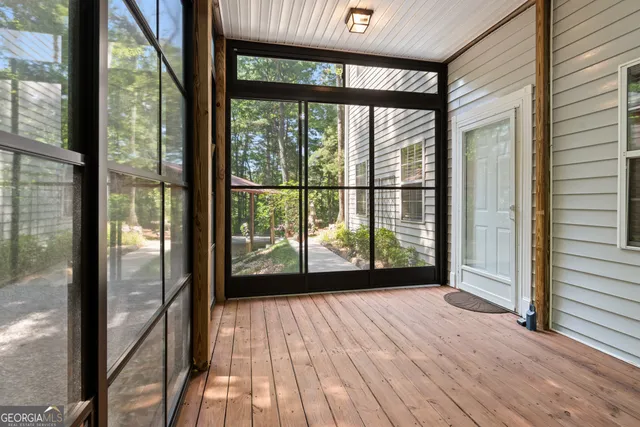 a view of empty room with wooden floor and floor to ceiling window