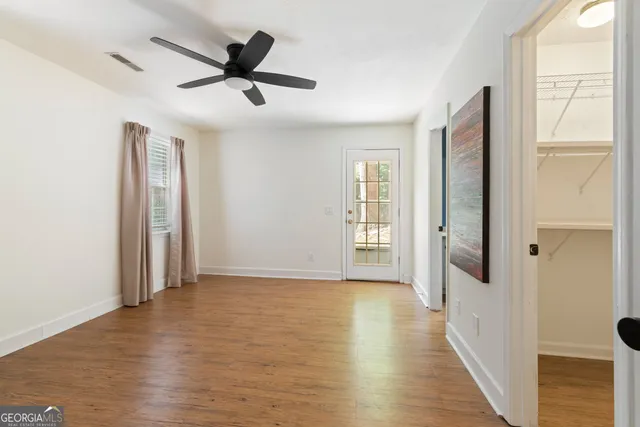 a view of a livingroom with wooden floor and a ceiling fan