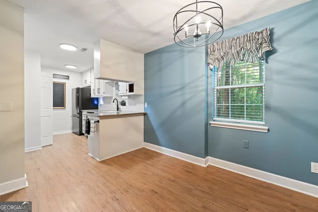 a view of a kitchen with wooden floor and a window