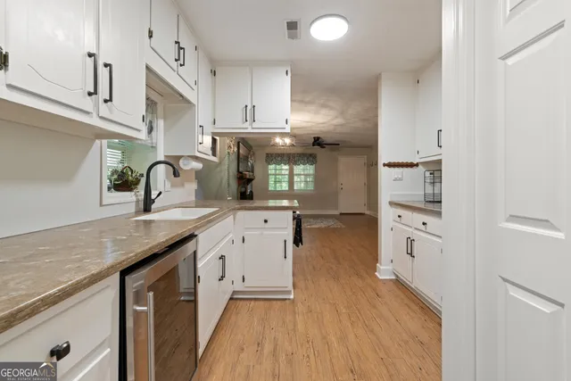 a kitchen with granite countertop a sink stove and cabinets