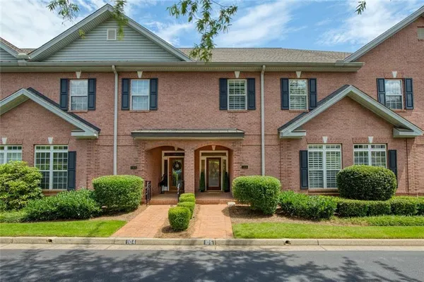 a front view of a house with a garden and plants