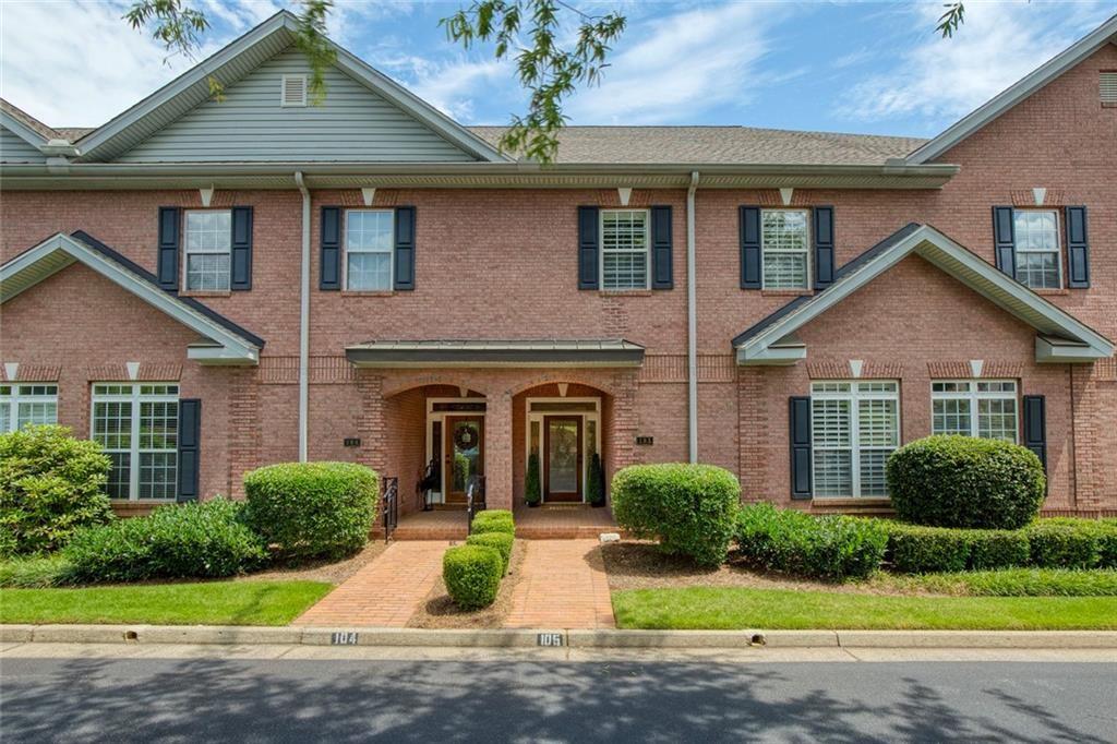 a front view of a house with a garden and plants