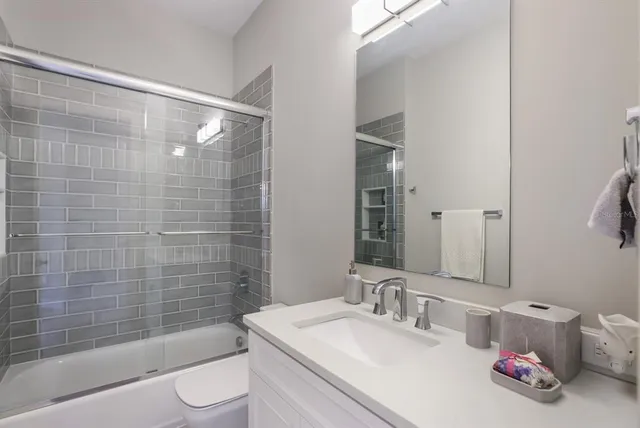 a bathroom with a sink toilet vanity and shower