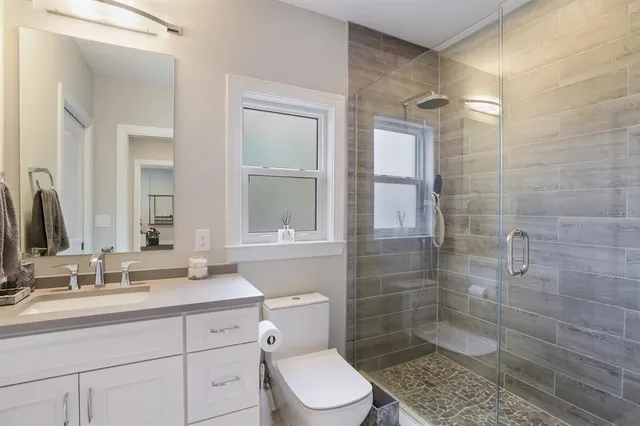 a bathroom with a sink a toilet and shower