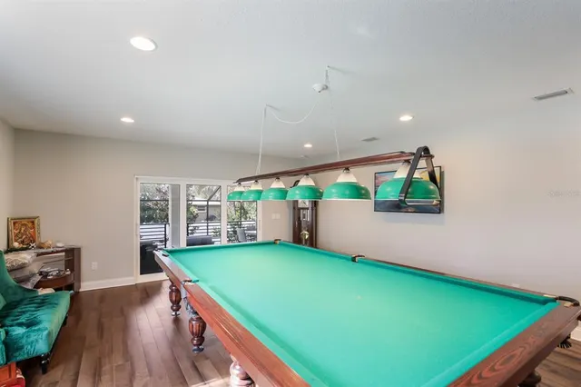 an open room with kitchen view and a wooden floor