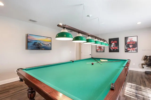 a room with pool table and windows