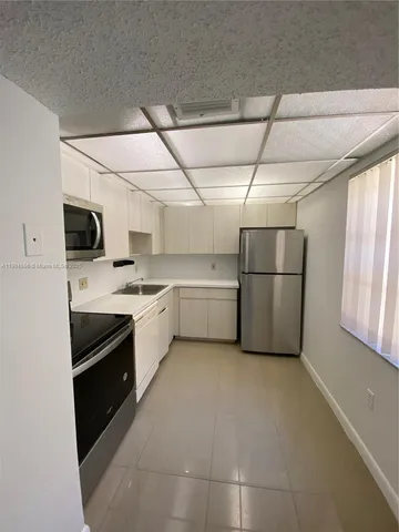 a kitchen with stainless steel appliances a refrigerator and a stove top oven