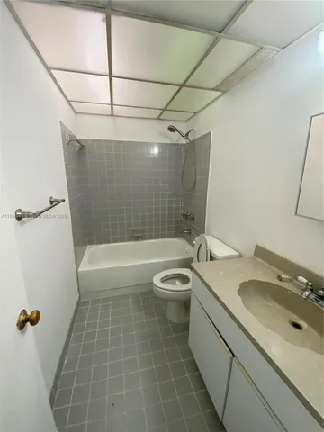 a bathroom with a granite countertop bathtub shower sink vanity and toilet