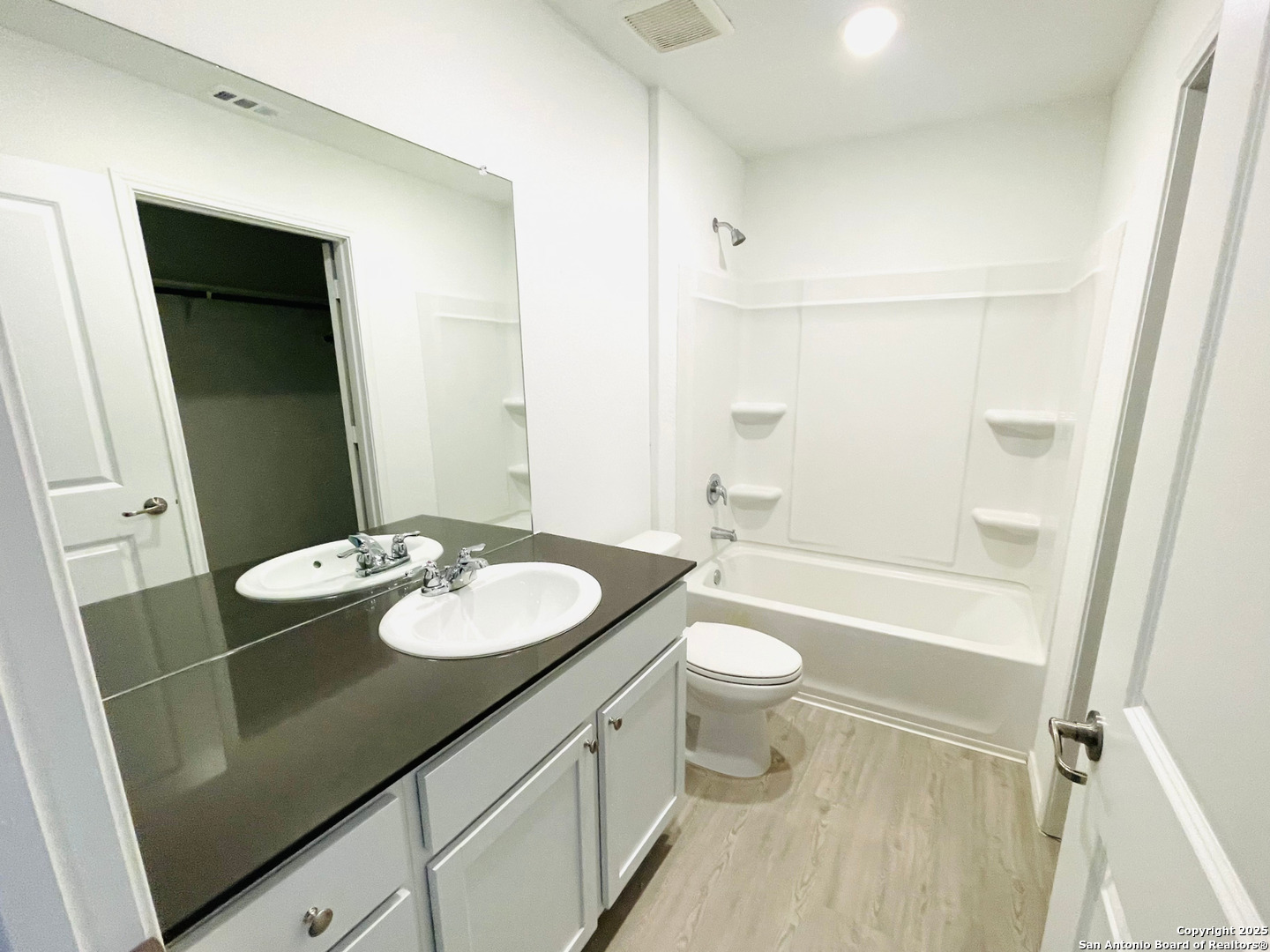 13307 Dutra Road San Antonio, TX 78221 - Photo 11 of 33 a bathroom with a granite countertop sink toilet a mirror and shower