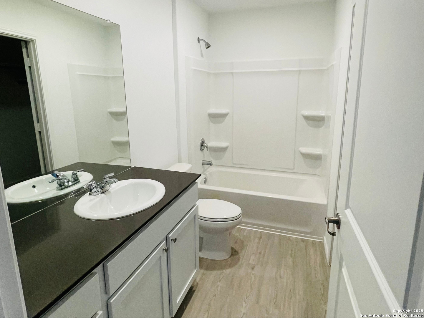 13307 Dutra Road San Antonio, TX 78221 - Photo 15 of 33 a bathroom with a granite countertop sink toilet a mirror and shower