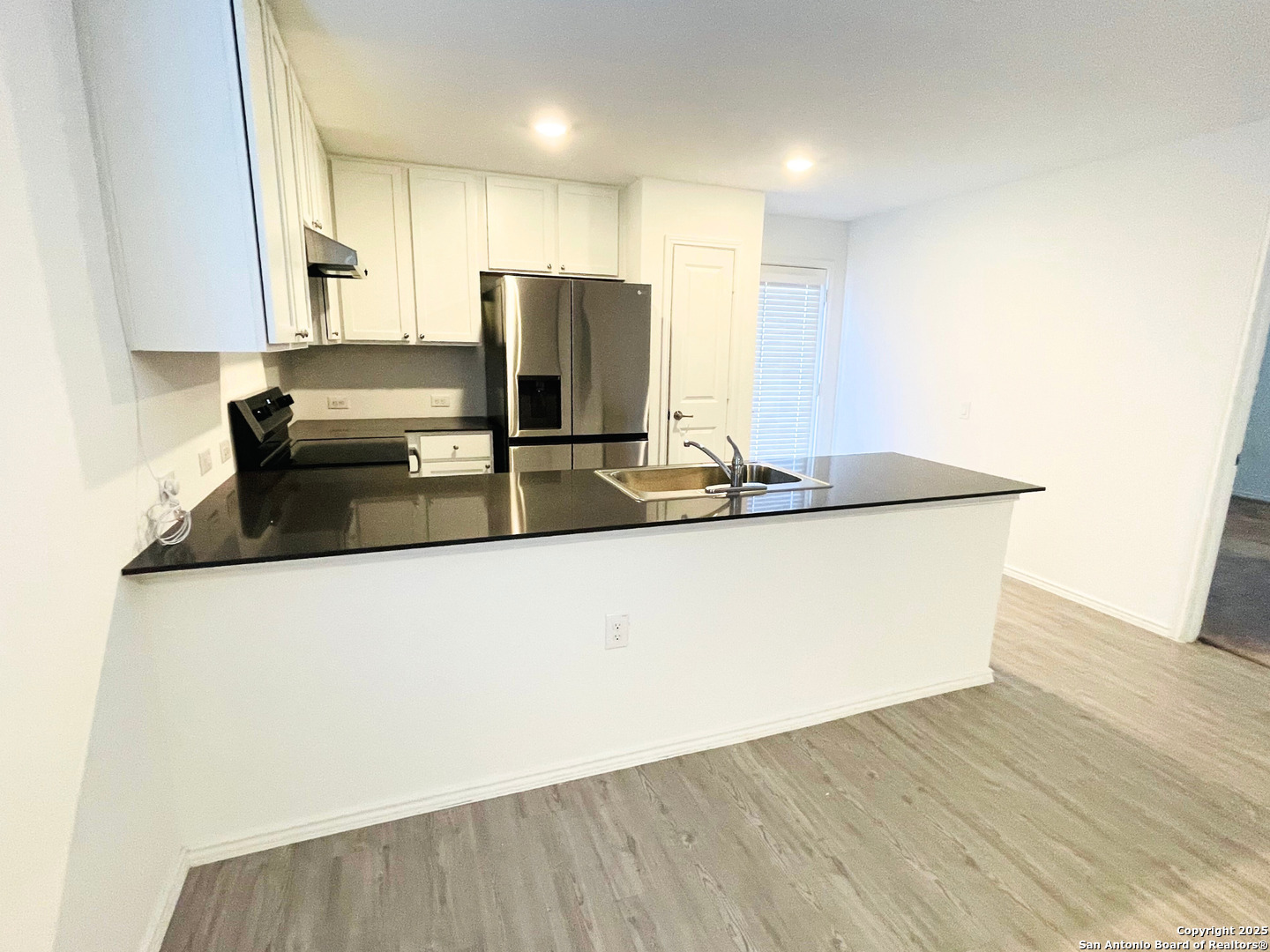 13307 Dutra Road San Antonio, TX 78221 - Photo 4 of 33 a kitchen with kitchen island a sink a stove a refrigerator and white cabinets