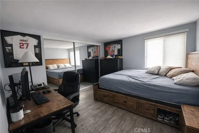 a bedroom with a bed and wooden floor