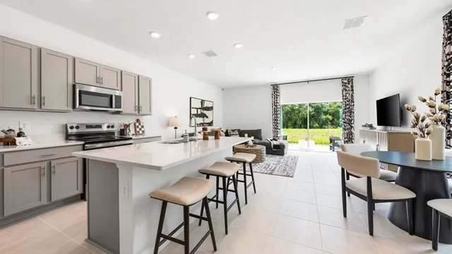 a living room with furniture a dining table and kitchen view