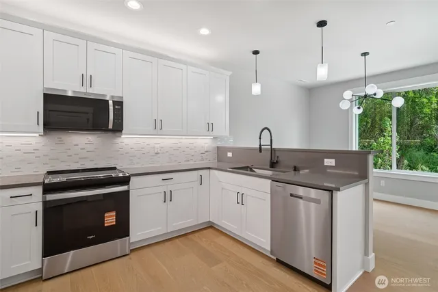 a kitchen with granite countertop a refrigerator stove and sink